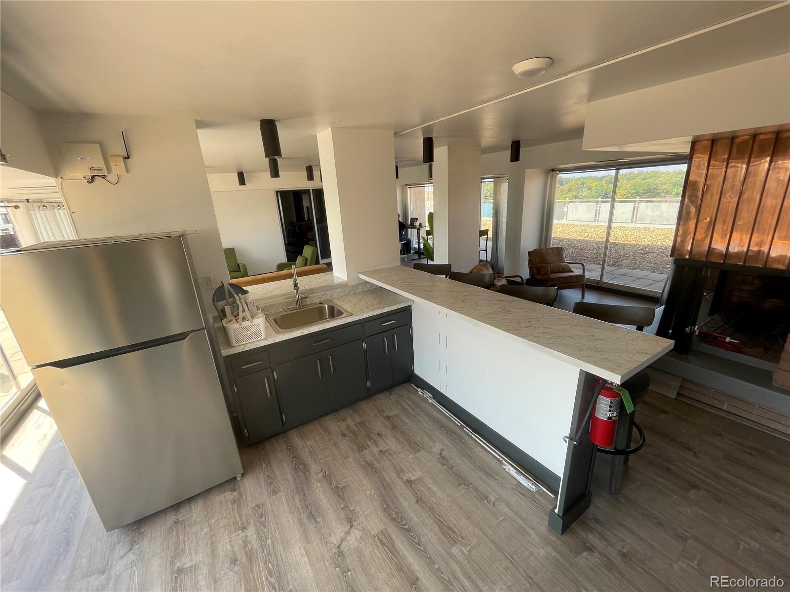 1121 Albion Street, Unit 709 Denver, CO 80220 - Photo 24 of 24 a kitchen with a refrigerator sink and wooden floor