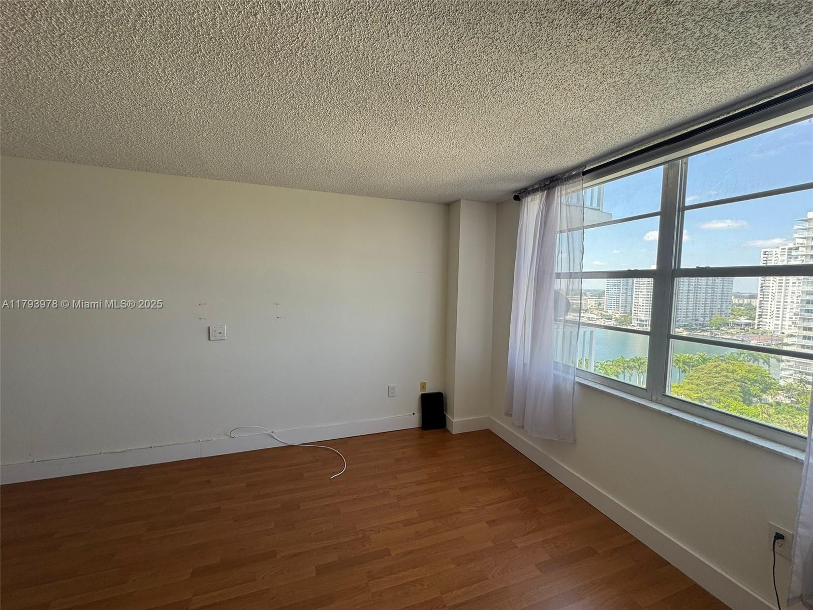 2851 Northeast 183rd Street, Unit 1408E Aventura, FL 33160 - Photo 11 of 24 an empty room with wooden floor and windows