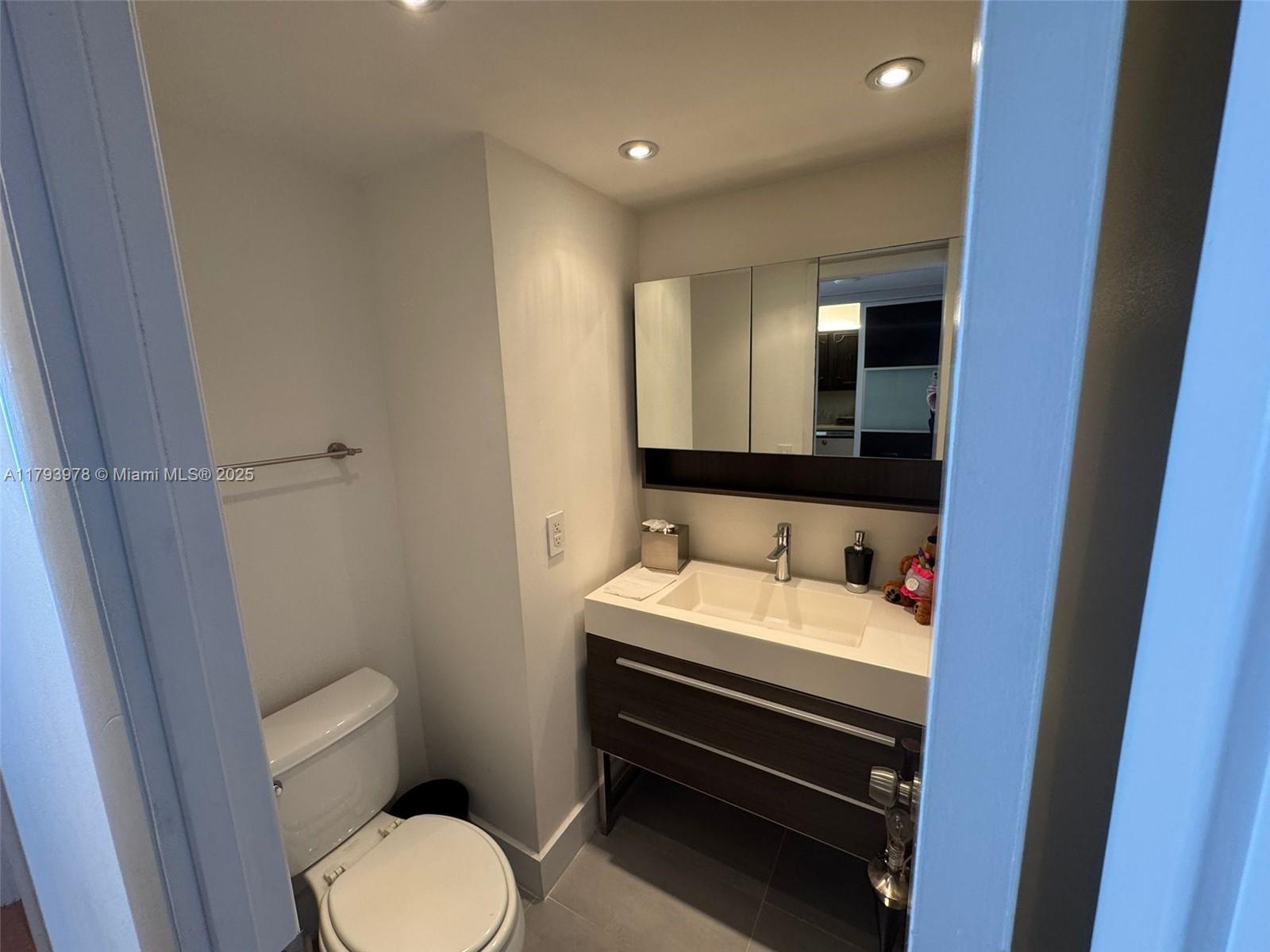 2851 Northeast 183rd Street, Unit 1408E Aventura, FL 33160 - Photo 18 of 24 a bathroom with a toilet sink and mirror