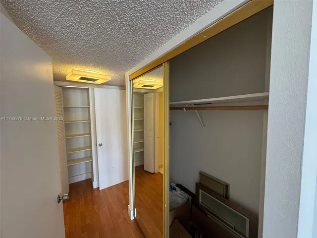 a view of walk in closet with wooden floor