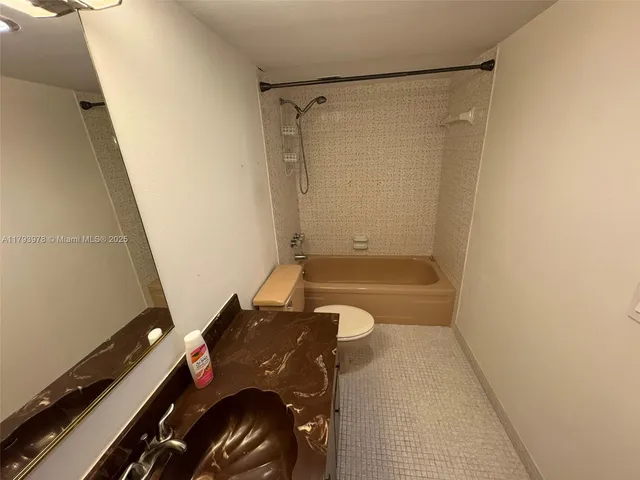a bathroom with a granite countertop sink a toilet and shower