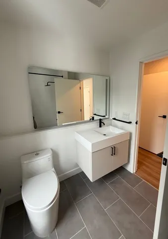 a bathroom with a toilet sink and mirror