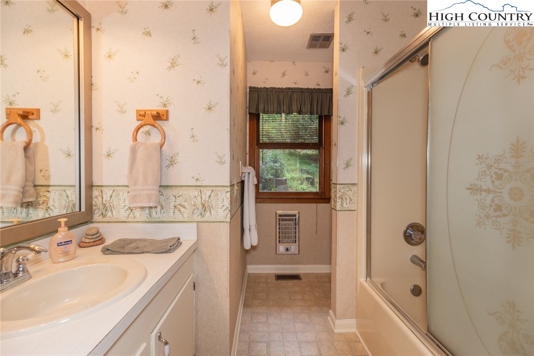 431 Roaring Ridge Road Deep Gap, NC 28618 - Photo 24 of 39 a bathroom with a sink a mirror and a bathtub