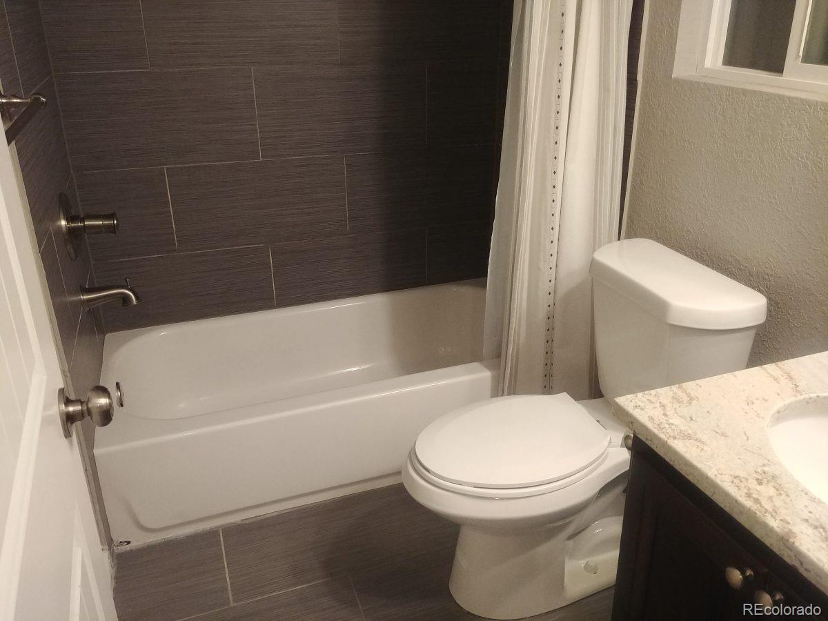 2918 Ames Street Wheat Ridge, CO 80214 - Photo 11 of 19 a white toilet and tub sitting next to a bathroom sink