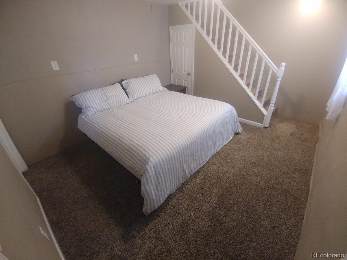 2918 Ames Street Wheat Ridge, CO 80214 - Photo 17 of 19 a bedroom with a bed and a stairs