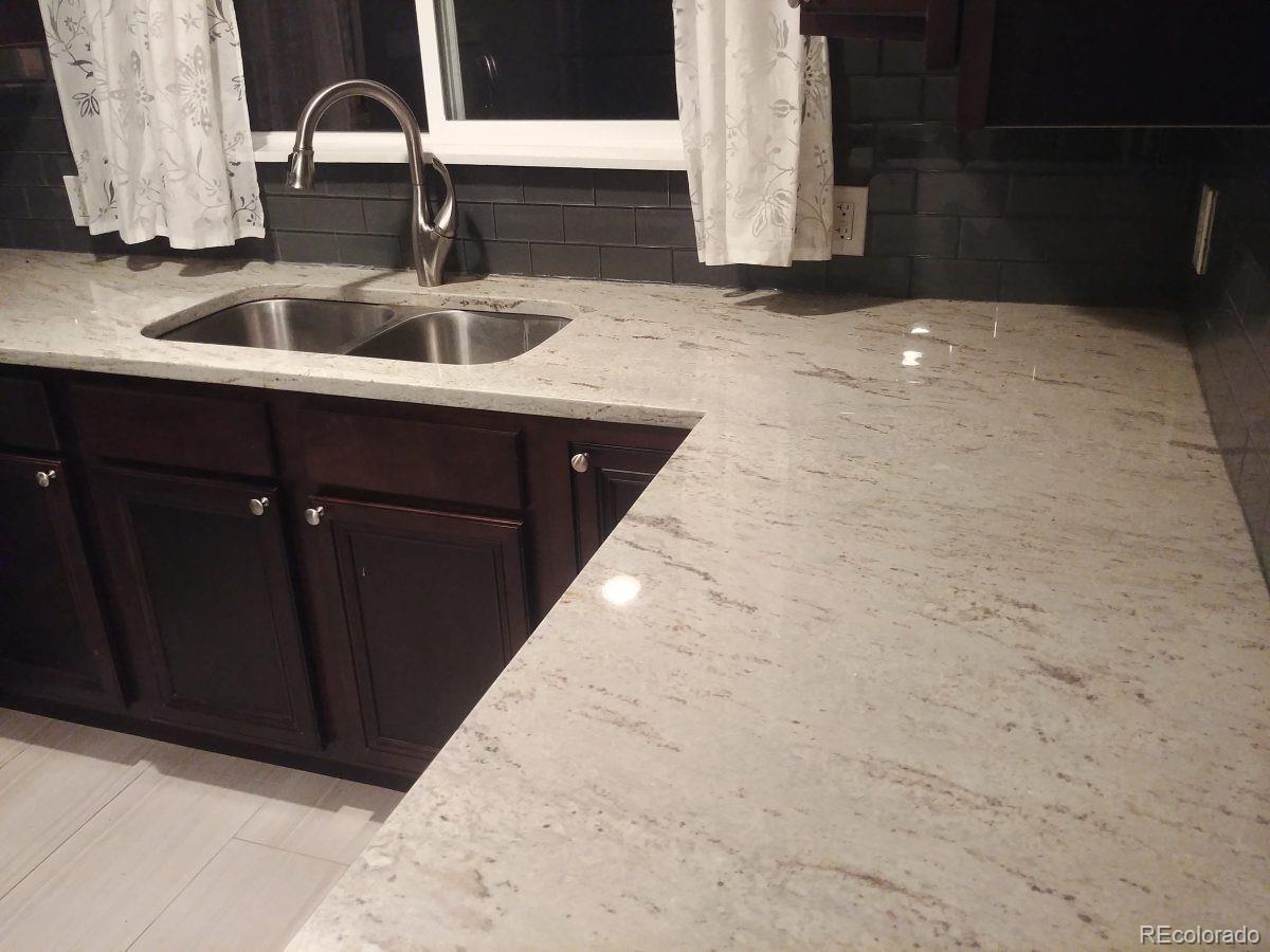 2918 Ames Street Wheat Ridge, CO 80214 - Photo 7 of 19 a kitchen with a sink and a stove