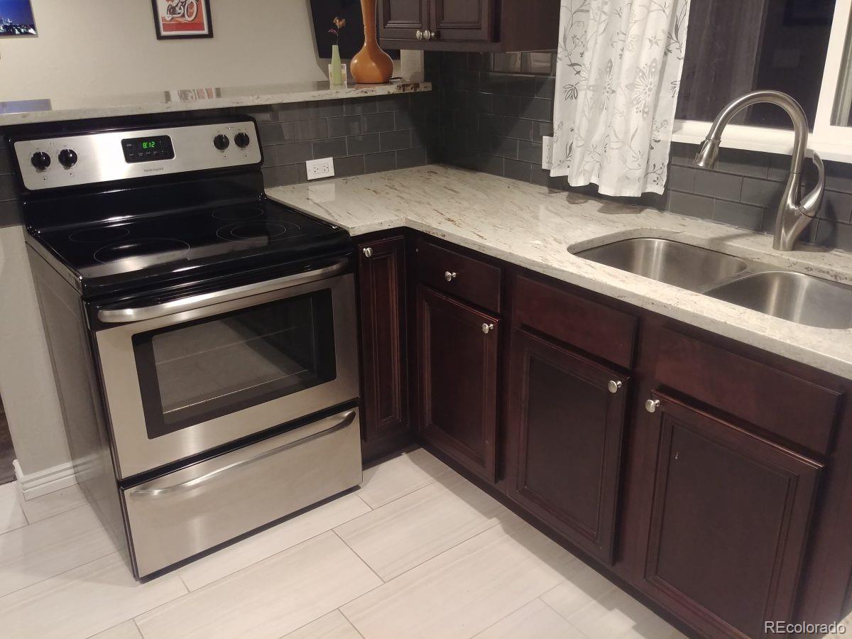 2918 Ames Street Wheat Ridge, CO 80214 - Photo 9 of 19 a kitchen with granite countertop a stove and a sink