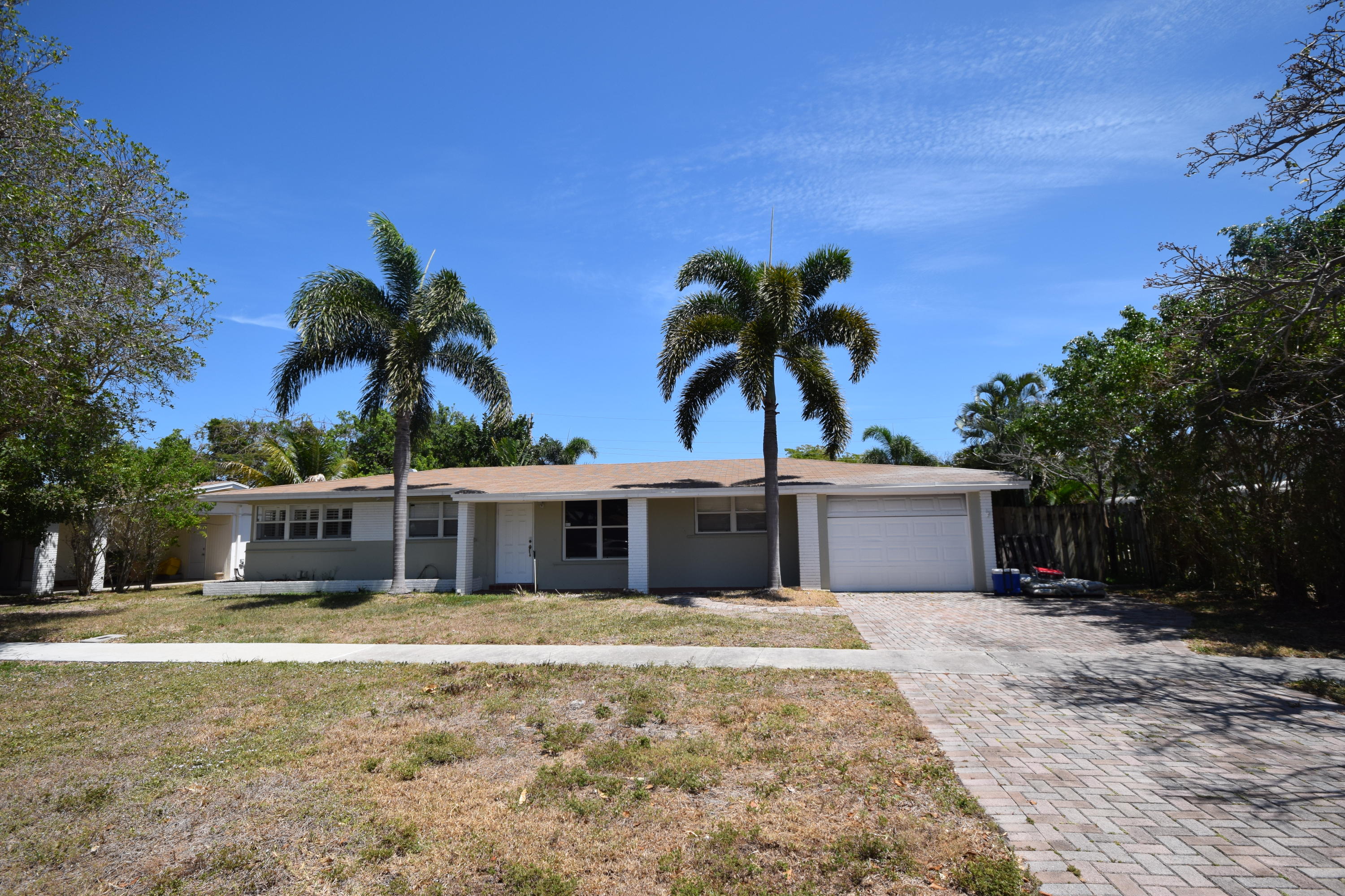 4710 Northwest 3rd Avenue Boca Raton, FL 33431 - Photo 2 of 17 a front view of a house with a garden and yard