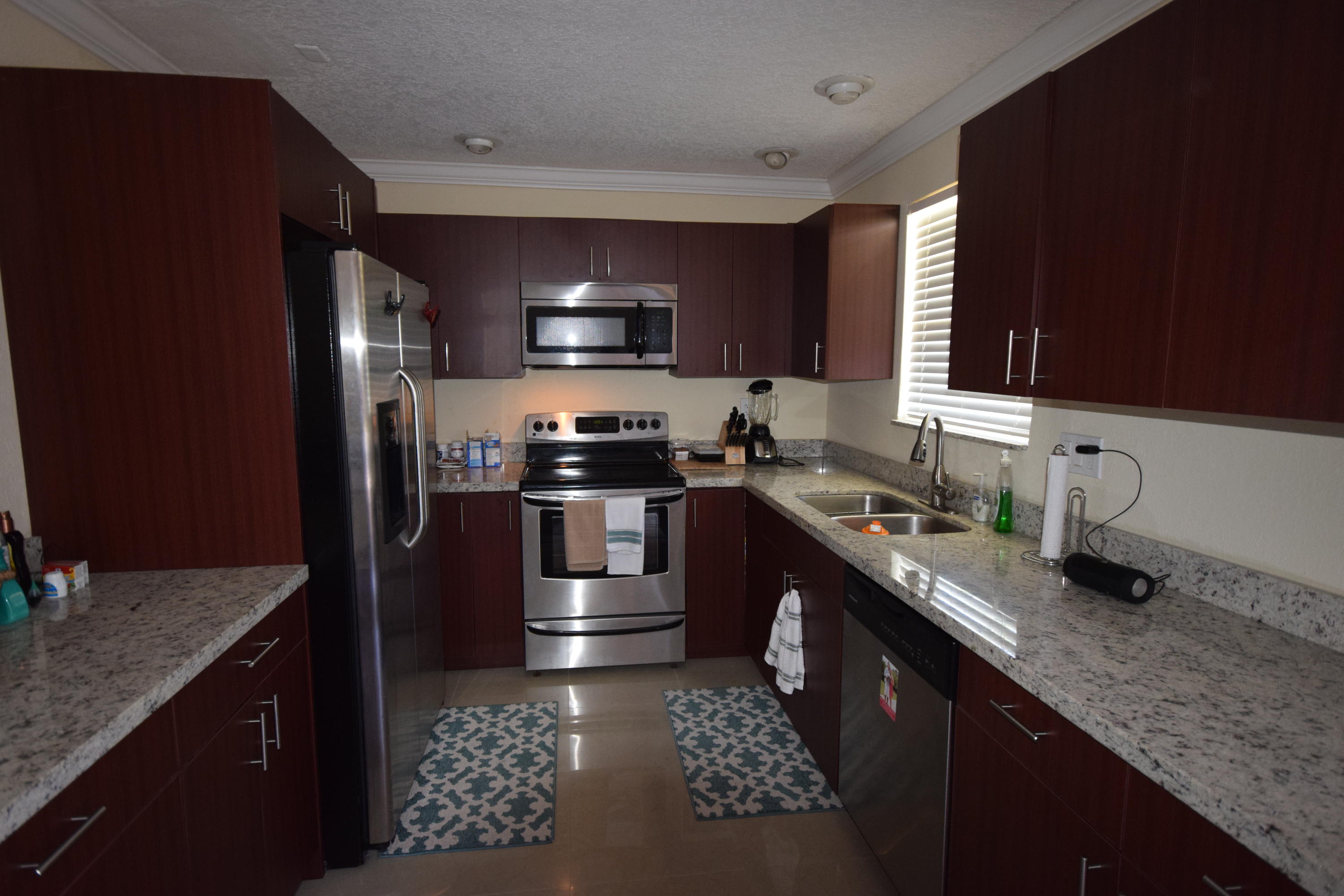 4710 Northwest 3rd Avenue Boca Raton, FL 33431 - Photo 3 of 17 a kitchen with stainless steel appliances granite countertop a sink stove and refrigerator