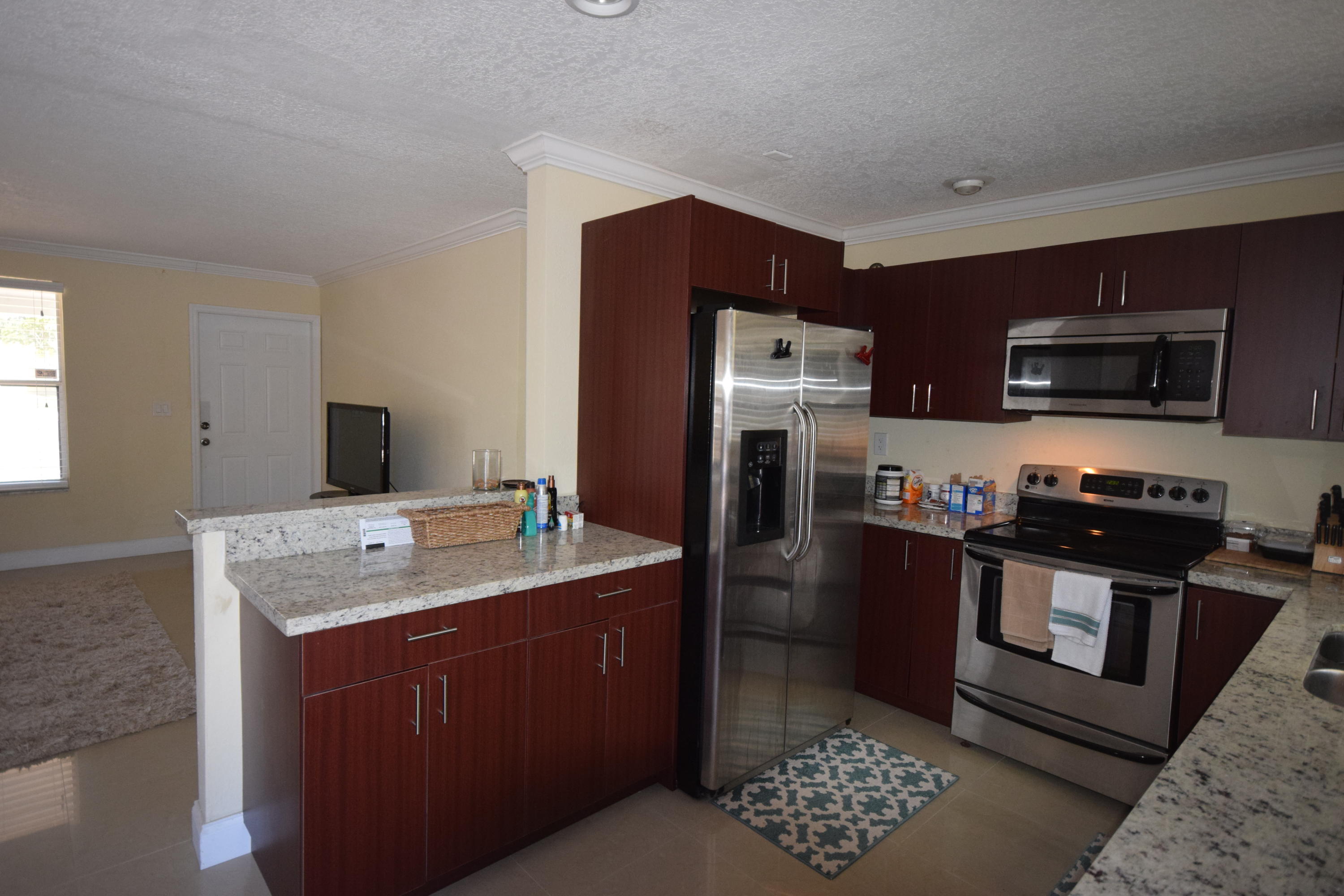 4710 Northwest 3rd Avenue Boca Raton, FL 33431 - Photo 4 of 17 a kitchen with stainless steel appliances kitchen island granite countertop a refrigerator stove and sink