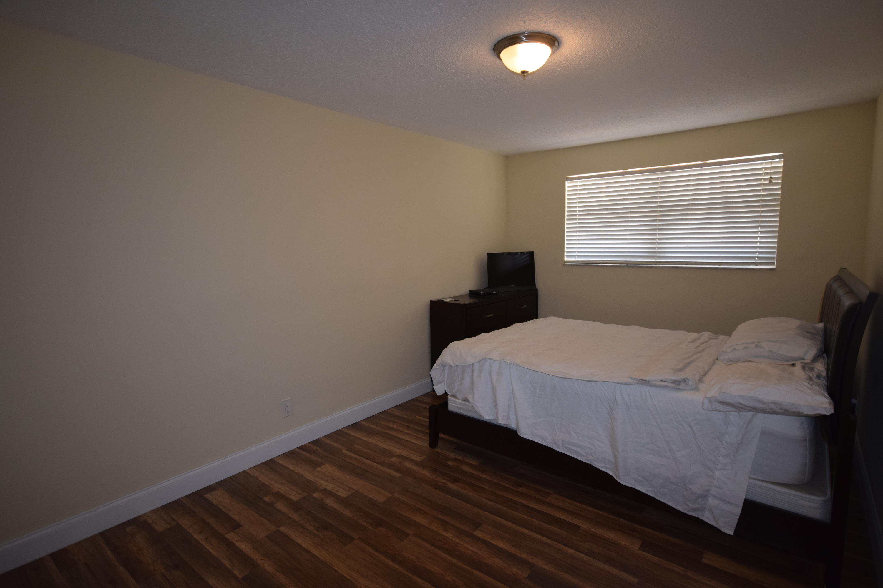 4710 Northwest 3rd Avenue Boca Raton, FL 33431 - Photo 8 of 17 a bed sitting in a bedroom next to a window