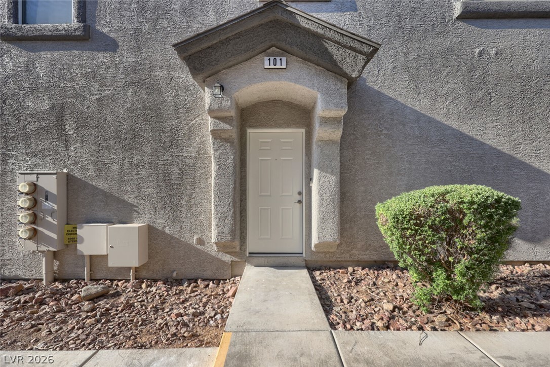 5985 High Steed Street, Unit 101 Henderson, NV 89011 - Photo 2 of 38 A welcoming entry framed by stucco archway, featuring a paneled door and low-maintenance landscaping.