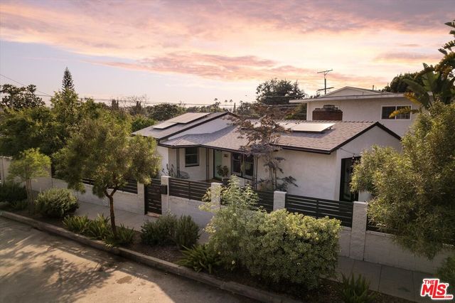 a front view of a house with a garden