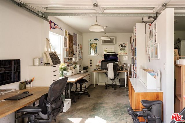 a view of a workspace with furniture and a window