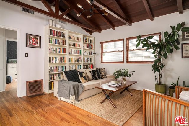 a living room with furniture a chandelier and a floor to ceiling window