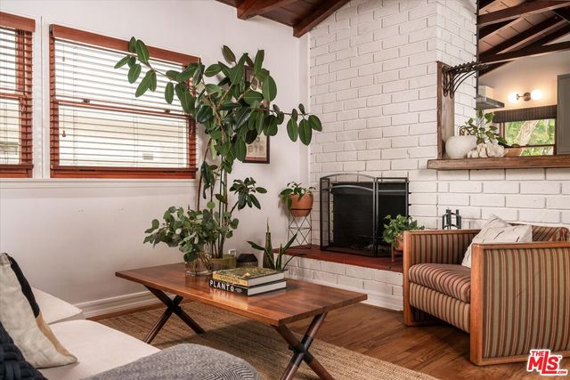 a living room with furniture a fireplace and a potted plant