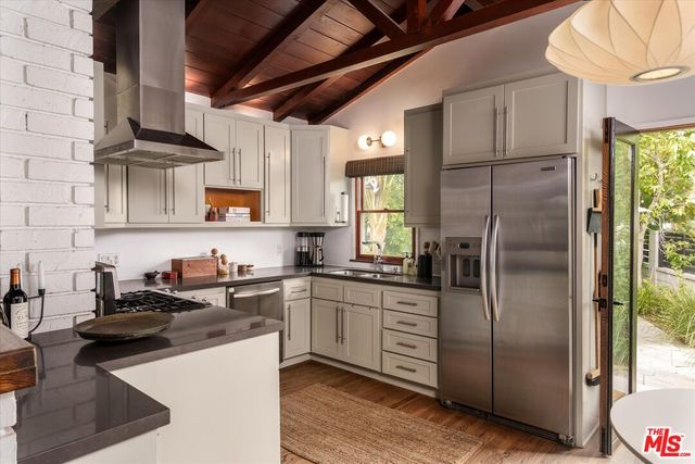 a kitchen with stainless steel appliances granite countertop a refrigerator a sink a stove and island