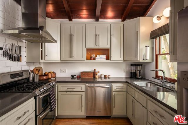 a kitchen with stainless steel appliances a sink a stove and a microwave