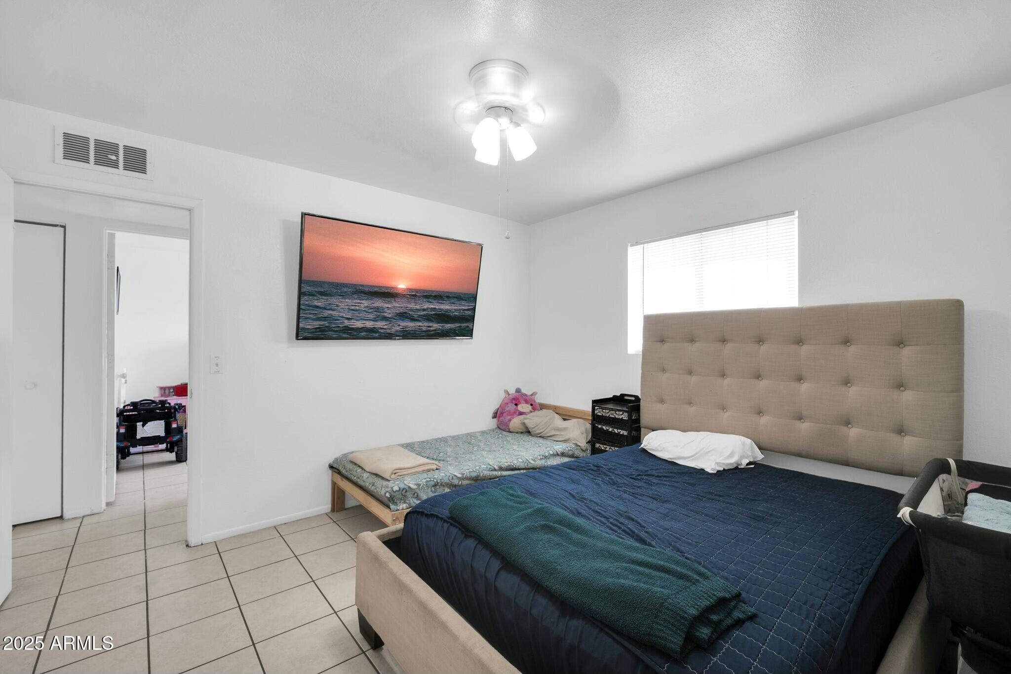 2929 West Granada Road Phoenix, AZ 85009 - Photo 11 of 28 a bedroom with a bed and a flat screen tv