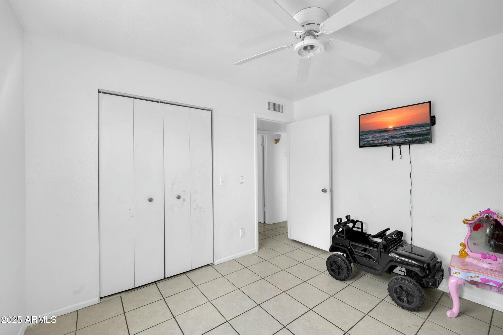 2929 West Granada Road Phoenix, AZ 85009 - Photo 13 of 28 a room with furniture and a flat screen tv