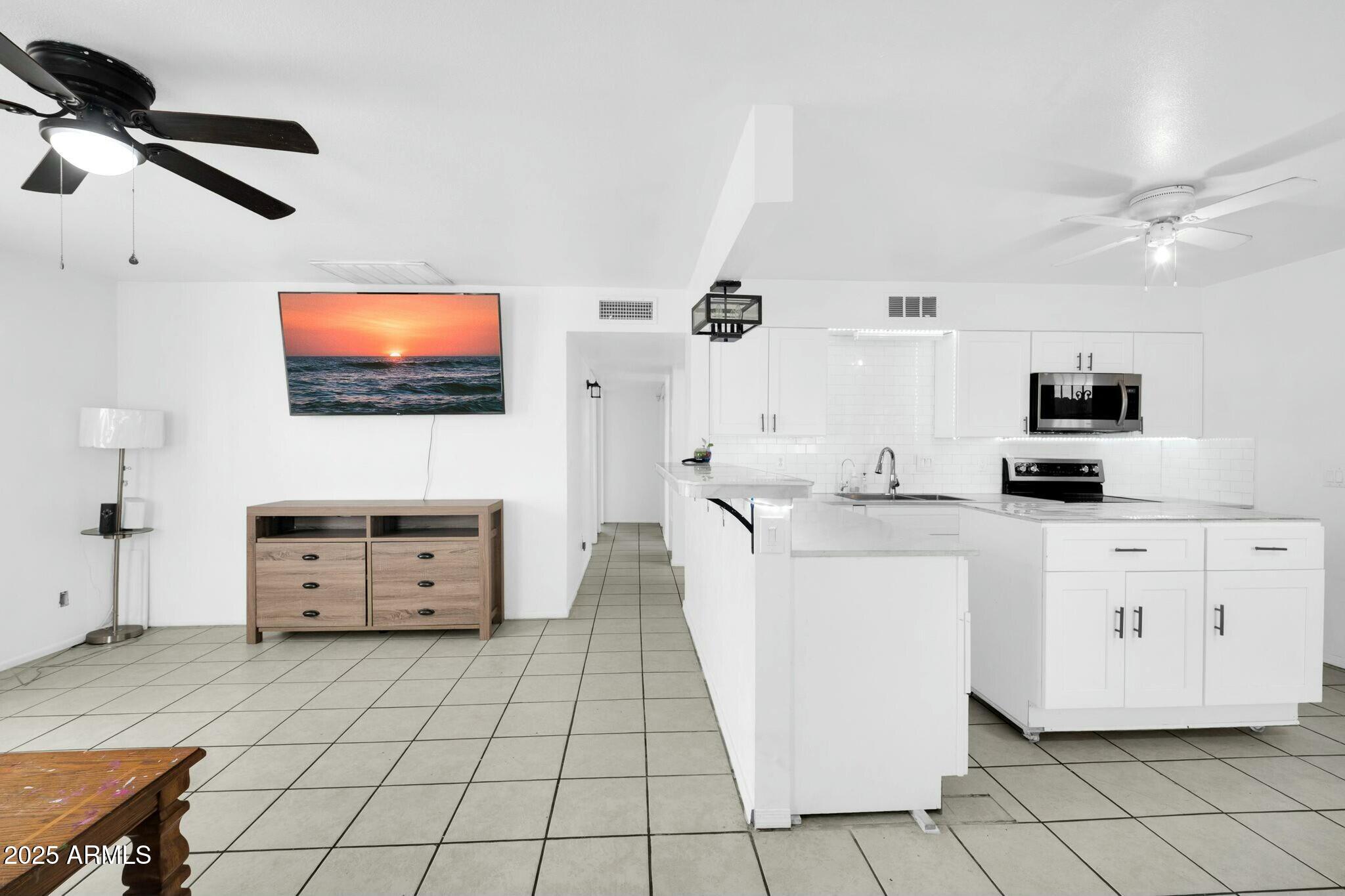 2929 West Granada Road Phoenix, AZ 85009 - Photo 4 of 28 a living room with furniture and a flat screen tv