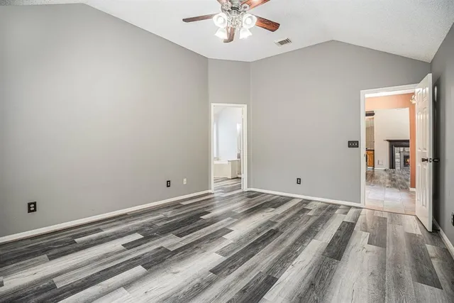 a view of a livingroom with wooden floor and a ceiling fan