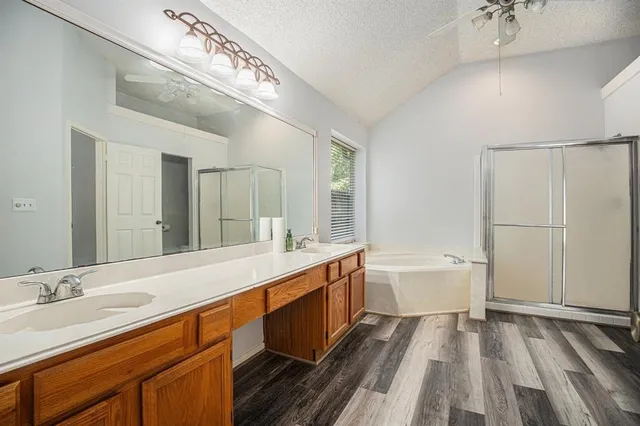 a spacious bathroom with a double vanity sink a mirror and a bathtub