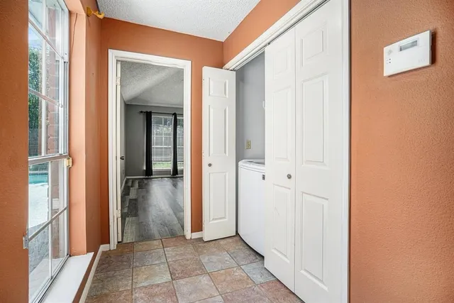 a view of a hallway with wooden floor and closet
