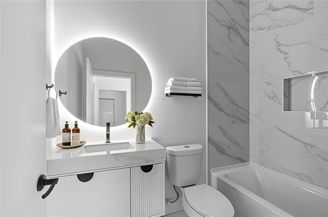 a bathroom with a granite countertop sink toilet and shower