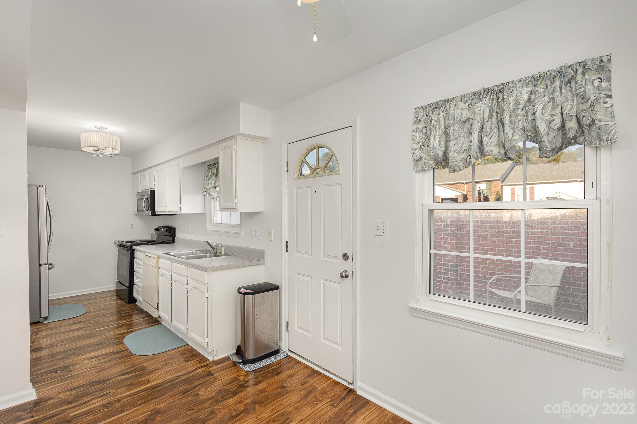 10927 Park Road Charlotte, NC 28226 - Photo 15 of 28 a kitchen with a sink cabinets wooden floor and a large window