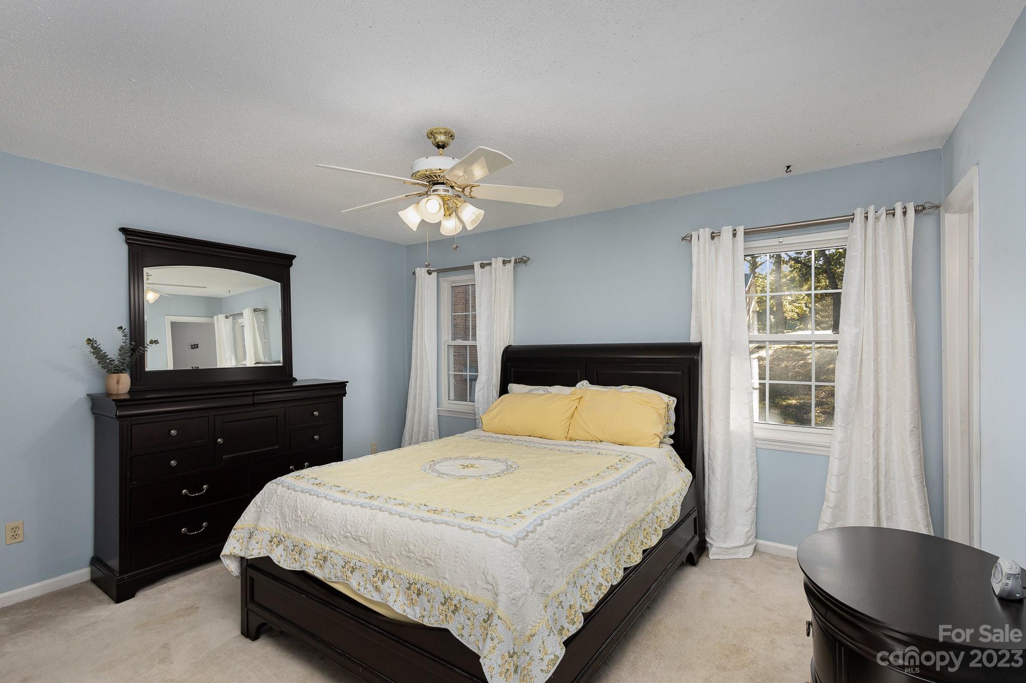10927 Park Road Charlotte, NC 28226 - Photo 17 of 28 a bedroom with a bed and a chandelier