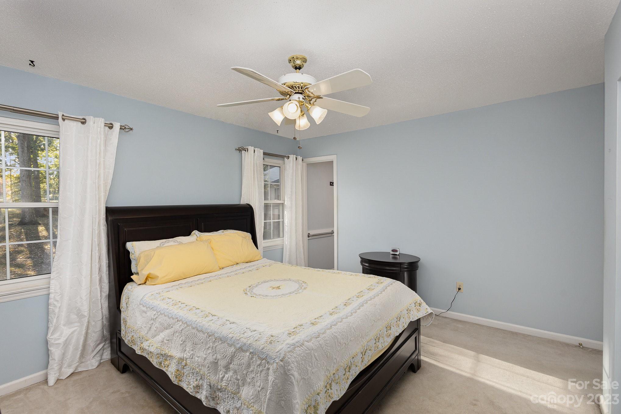 10927 Park Road Charlotte, NC 28226 - Photo 18 of 28 a bedroom with a bed and a chandelier