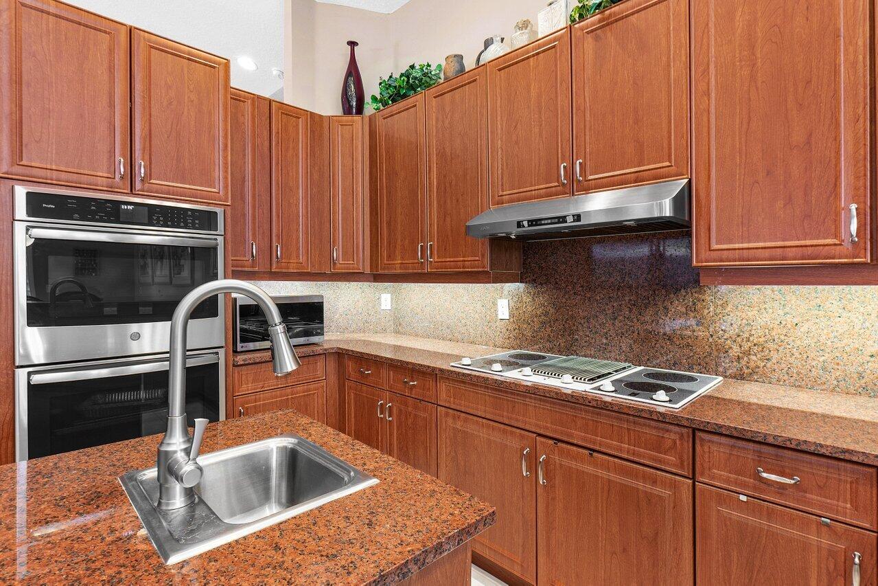 9031 Long Lake Palm Drive Boca Raton, FL 33496 - Photo 14 of 53 a kitchen with stainless steel appliances granite countertop a sink a stove and cabinets