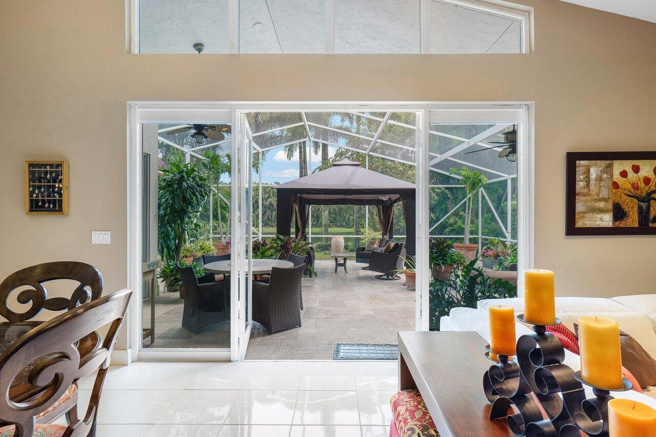 9031 Long Lake Palm Drive Boca Raton, FL 33496 - Photo 20 of 53 a view of a patio with a dining table and chairs