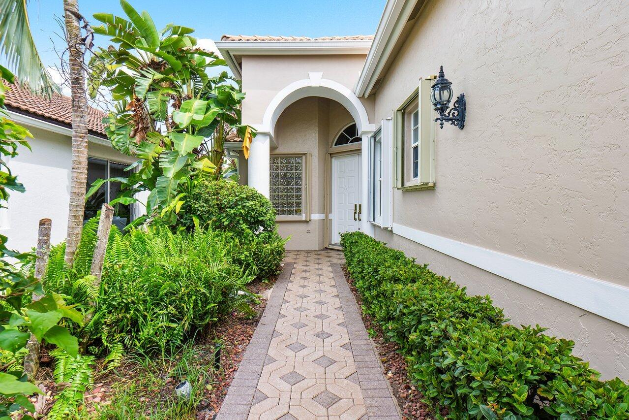 9031 Long Lake Palm Drive Boca Raton, FL 33496 - Photo 2 of 53 a view of a pathway of a house with potted plants