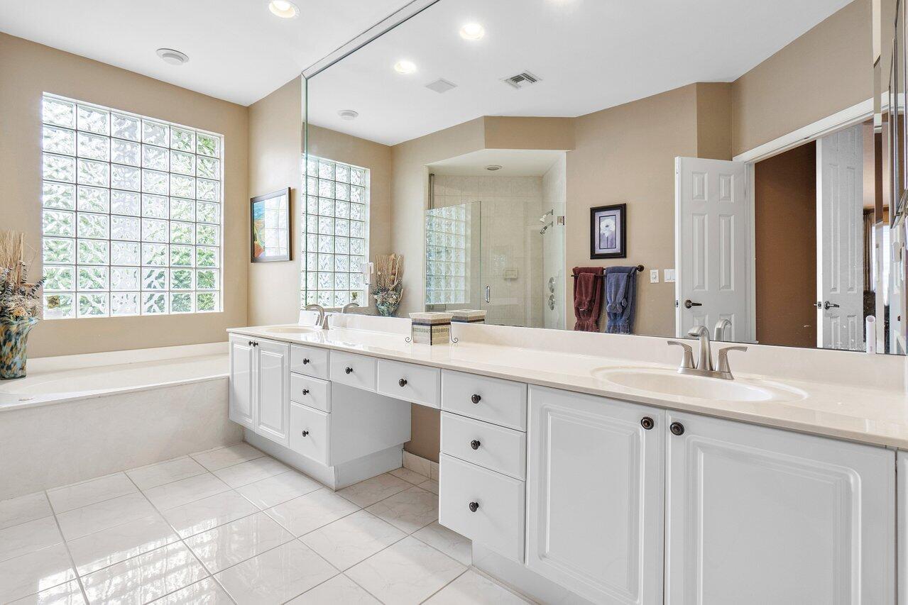 9031 Long Lake Palm Drive Boca Raton, FL 33496 - Photo 26 of 53 a spacious bathroom with a granite countertop sink mirror and a bathtub