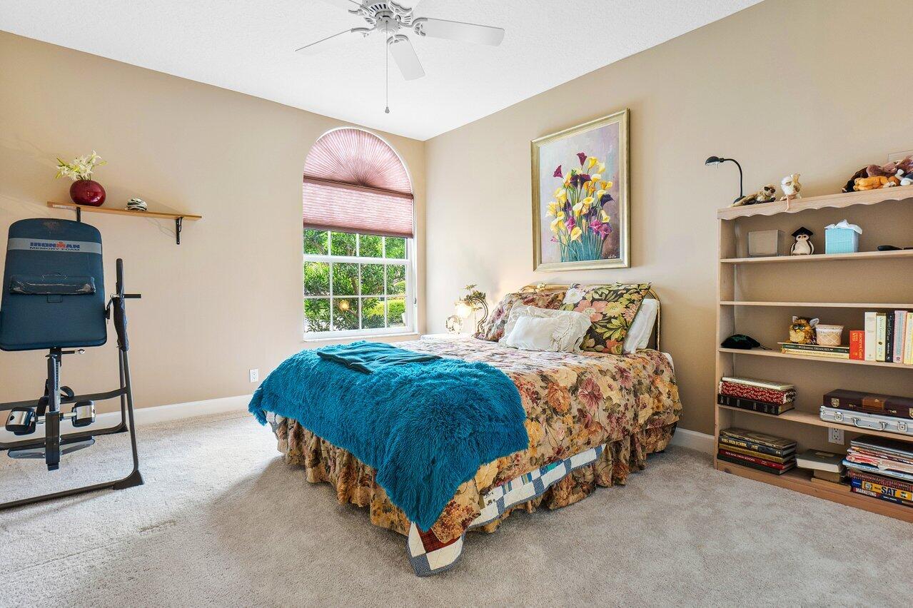 9031 Long Lake Palm Drive Boca Raton, FL 33496 - Photo 39 of 53 a bed sitting in a bedroom next to a window with a book shelf