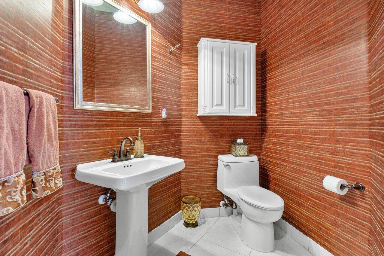 9031 Long Lake Palm Drive Boca Raton, FL 33496 - Photo 5 of 53 a bathroom with a toilet sink and mirror