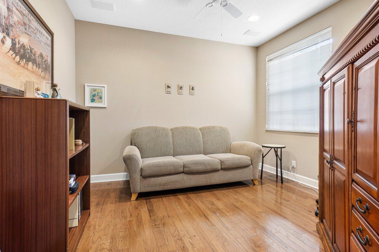 9031 Long Lake Palm Drive Boca Raton, FL 33496 - Photo 6 of 53 a living room with furniture wooden floor and a refrigerator
