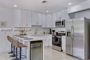 1401 Southwest 3rd Avenue Dania Beach, FL 33004 - Photo 11 of 13 a kitchen with stainless steel appliances granite countertop a stove a refrigerator and a microwave