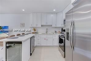 1401 Southwest 3rd Avenue Dania Beach, FL 33004 - Photo 12 of 13 a kitchen with stainless steel appliances granite countertop a sink stove and refrigerator