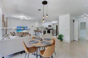 1401 Southwest 3rd Avenue Dania Beach, FL 33004 - Photo 6 of 13 a kitchen with stainless steel appliances kitchen island a dining table and chairs