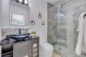 1401 Southwest 3rd Avenue Dania Beach, FL 33004 - Photo 9 of 13 a bathroom with a sink toilet a mirror and shower