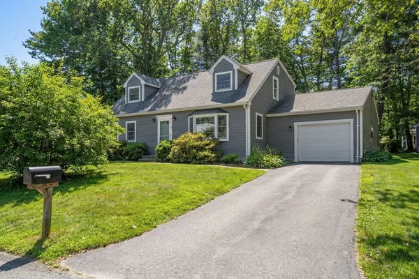 a front view of a house with a yard and trees