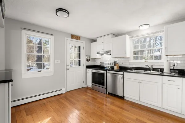 a kitchen with granite countertop white cabinets and white appliances
