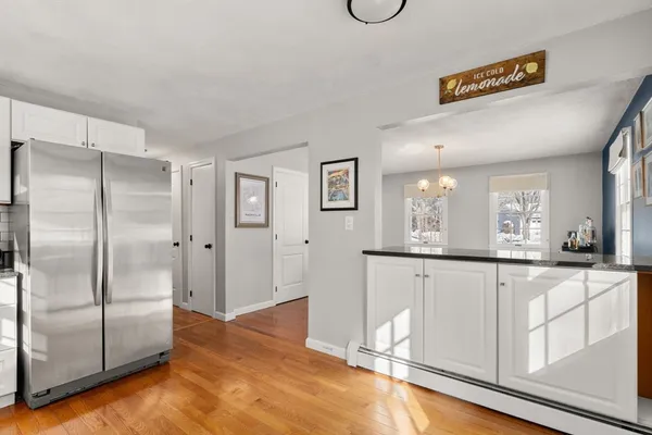 a kitchen with granite countertop a refrigerator and cabinets