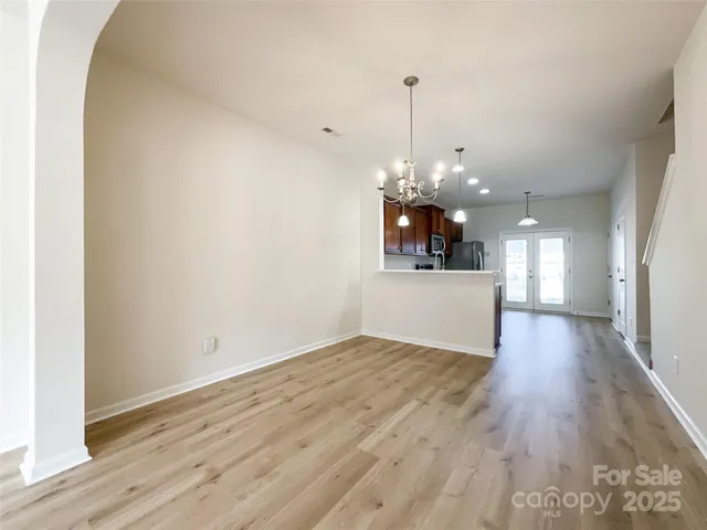 a view of a room with wooden floor and kitchen view