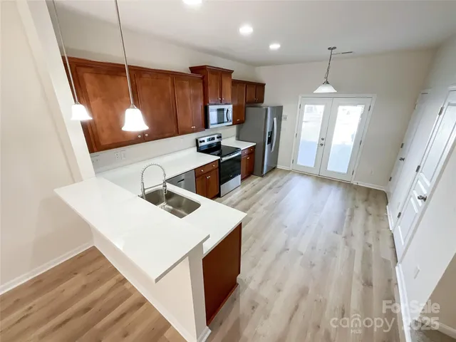 a kitchen with a sink a window a oven and wooden floors