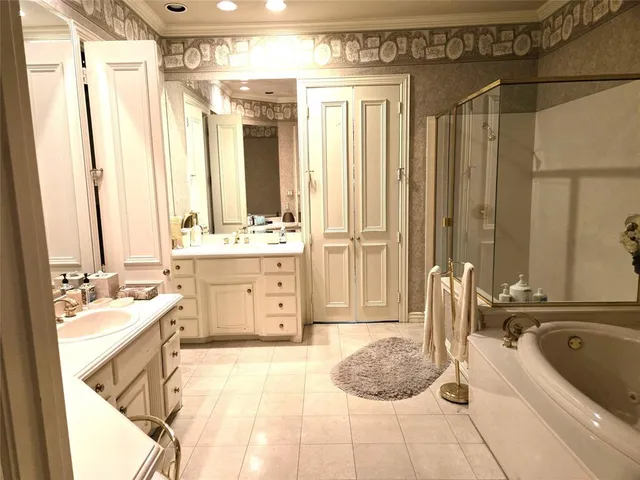 a spacious bathroom with a double vanity sink a mirror a bathtub and next to a window