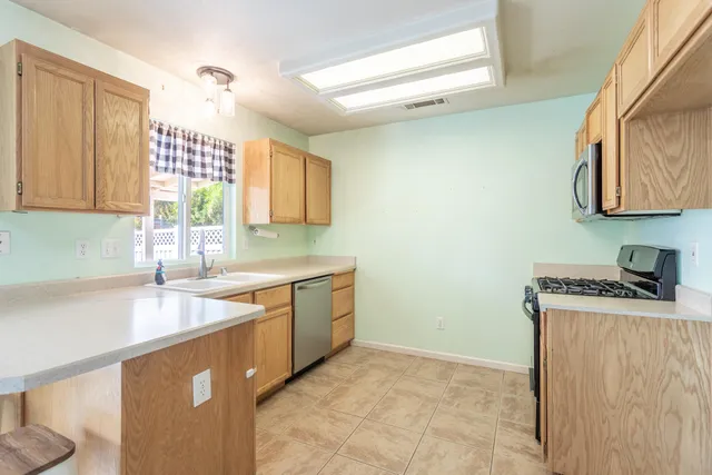 a kitchen with stainless steel appliances granite countertop a sink stove and cabinets